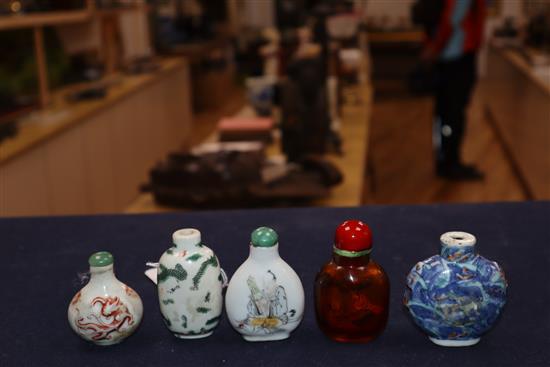 Four 19th century porcelain snuff bottles and an inside painted amber glass snuff bottle